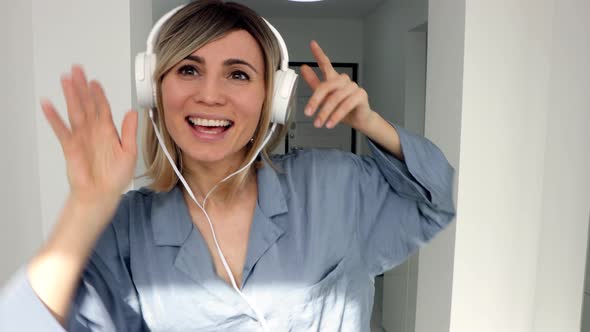 Portrait of cheerful european woman in headphones listening to music