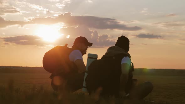 The Silhouette of Two Man on the Top of Mountain with Backpacks and Other Gear Expressing Energy alt