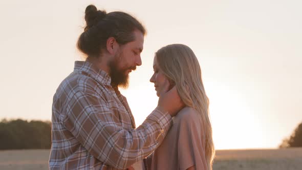 Loving Husband Bearded Man Strokes Face of Woman Beloved Girl and Hugging Close Up Sunset Background alt