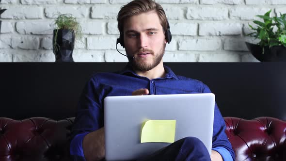 Happy young businessman is analizing financial documents from home during self isolation on laptop. alt