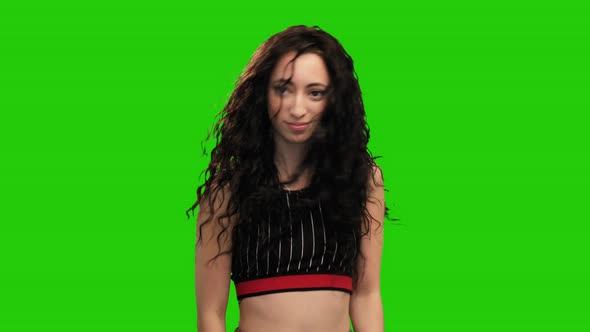 Portrait of long haired brunette girl in crop top dancing on green screen alt
