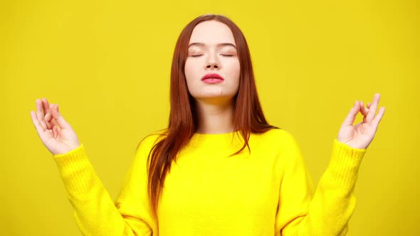Middle Shot of Slim Cute Redhead Woman Meditating at Yellow Background alt