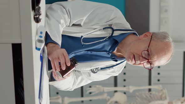 Vertical Video Senior Specialist Giving Health Care Treatment in Bottle alt