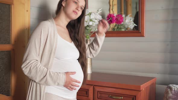 Happy Natural Beauty Pregnant Woman Without Makeup Touching Tummy at Home Near Window