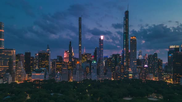 Day transitions to night, aerial sliding shoot of New York City at blue hour, with avenues crossing alt