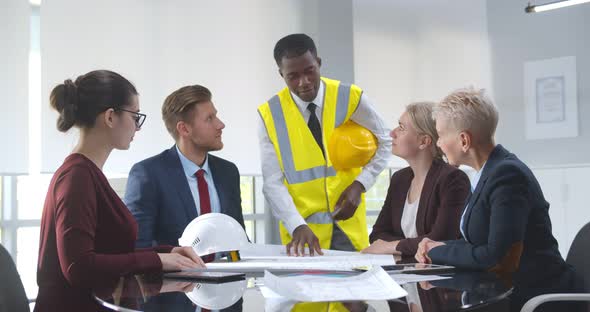 Diverse Group of Engineers Technicians and Specialists on Meeting Analyze Technical Drafts alt