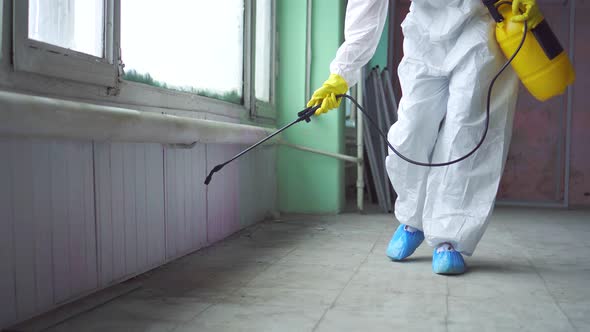 Exterminator in Overalls Carries Out Processing of the Room From a Mold alt