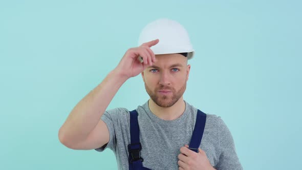 Serviceman in Overalls Putting on a Helmet alt