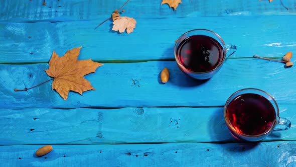 Beautiful Autumn Background With Yellow Foliage On A Wooden Table With A Mug Of Red Tea.