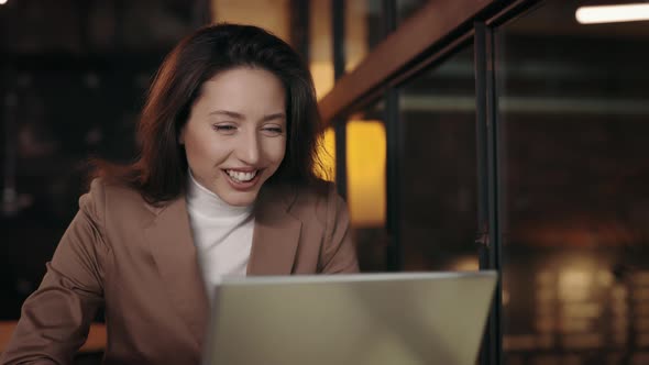 Woman Sitting at Cafe with Laptop and Reading Great News alt