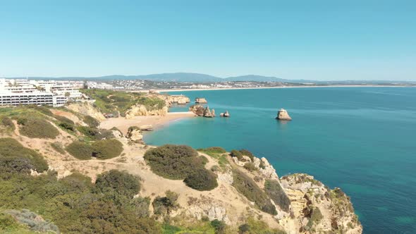 Rugged Coastline steep cliffs bordering Dona Ana beach in Lagos, Algarve, Portugal alt