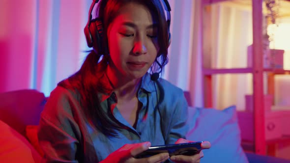 Asia girl gamer competition video game online with smartphone excited talk with friend..