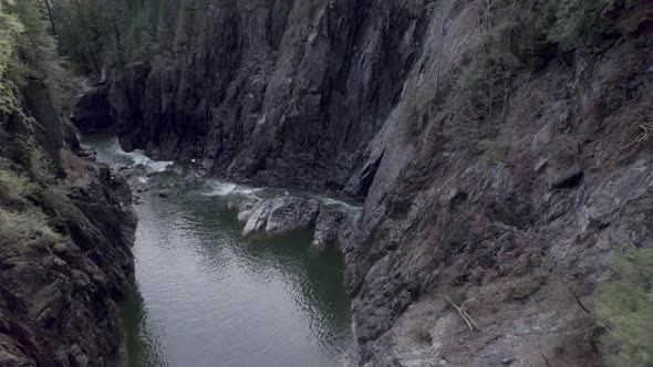 Drone fly inside rock canyon formation in Capilano River Regional Park in the District of North Vanc alt