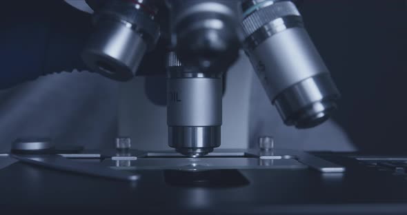 Sample Slide and Microscope with Metal Lens at Laboratory. alt