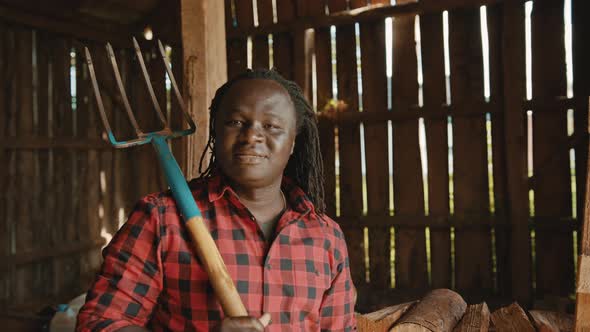 African Farmer Holding Fork Over His Shoulder in the Barn alt