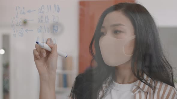 Asian Woman Writing on Glass Board alt