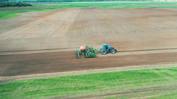 Massive Field with a Seeding Machine Riding Along It alt