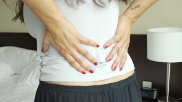 Woman massaging lower back, midsection