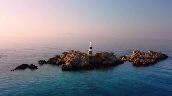 White lighthouse on the cliffs at an orange sunset