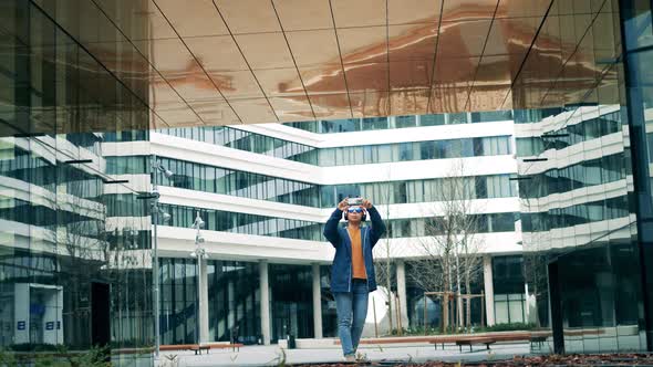 A Woman Is Taking Photos of Modern Urban Buildings alt