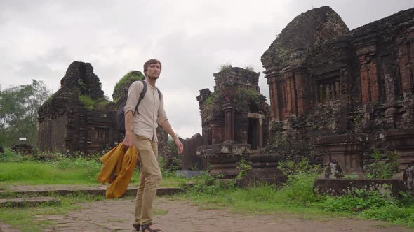 A Young Man Tourist Is Walking Through Ruins in the My Son Sanctuary Remains of an Ancient Cham alt