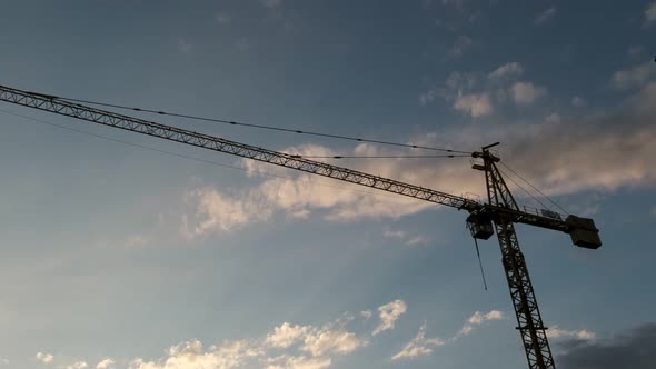 Silhouettes of construction tower crane and blue sky