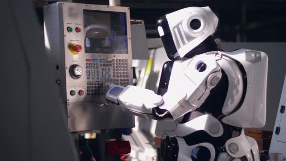 Working Droid Pushes on Buttons on a Factory Machine. alt