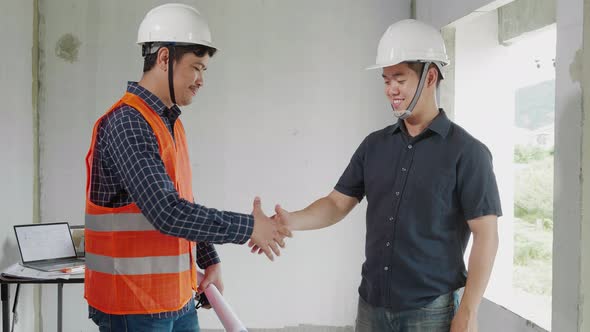 Two Construction engineer handshaking together at the construction site
