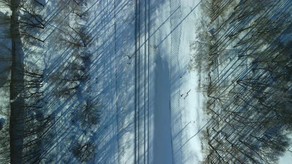 Flight Over The Railroad. A Train Runs Along The Rails. Winter Industrial Landscape. alt