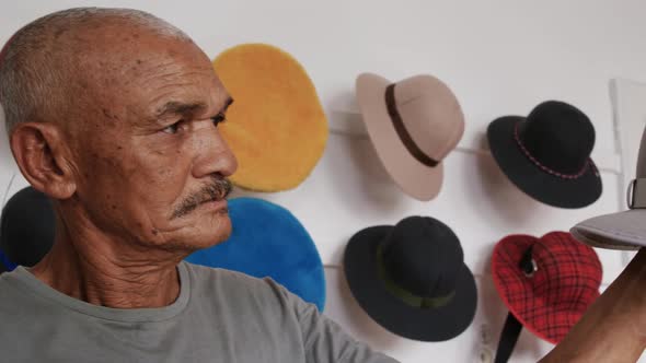 Mixed race man working at a hat factory alt