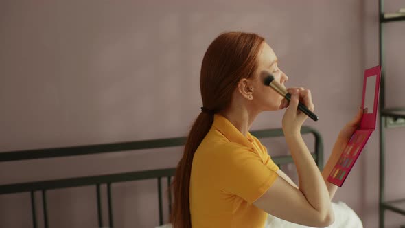 Redhead Young Woman with Natural Beauty Making Makeup Using Cosmetic Brush Applying Face Powder