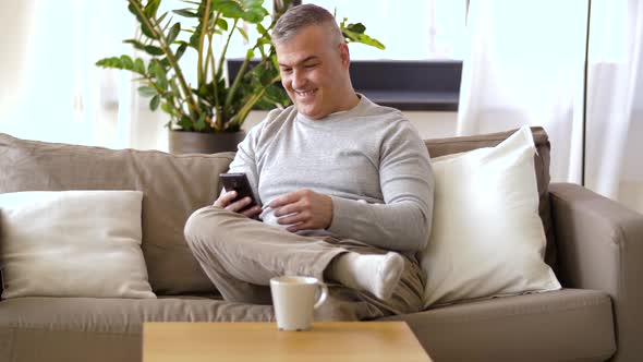 Man with Smartphone Drinking Coffee at Home 35 alt