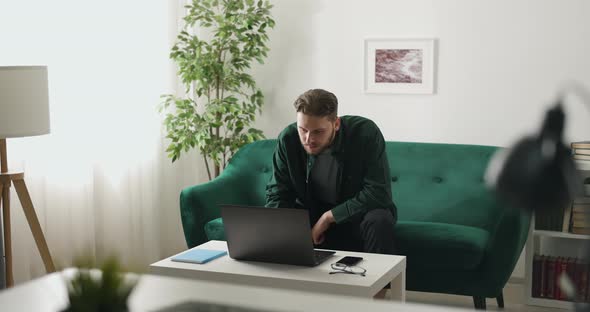 Man Working at Home with Laptop