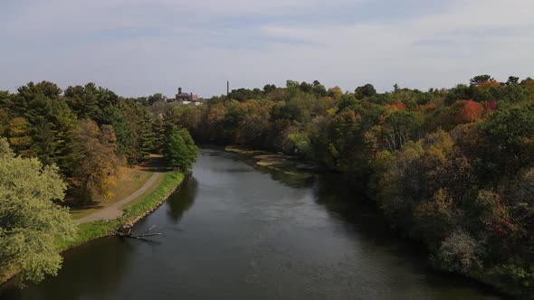 Aerial view over river then slowly coming in for landing on the water flowing through the forest.