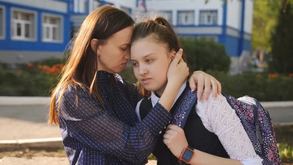 Mom at Sunset Calms Unsettled Teenage Girl in the Courtyard of the College alt