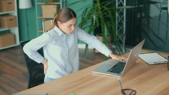 Woman Trying to Get Up From the Table Suddenly Feeling Pain in Back alt
