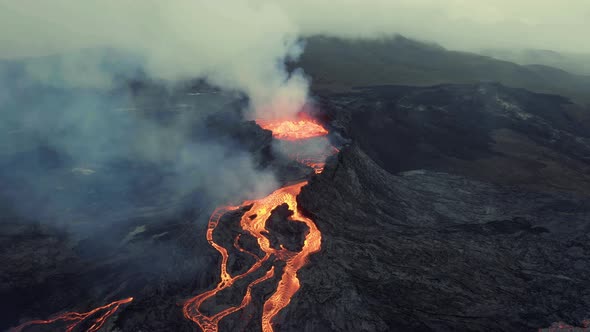 Aerial view around a Volcanic crater, in middle of smoke - circling, drone shot alt