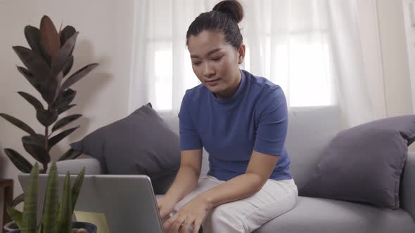 Asian businesswoman are using cards to pay for online shopping on a laptop alt