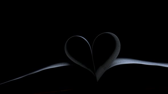 A Beam of Light Slowly Glides Into the Dark Studio and Illuminates an Open Book the Pages alt