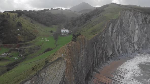 Aerial drone shot of a man over a cliff with hands up. Stunning nature landscape. Freedom feeling. O alt