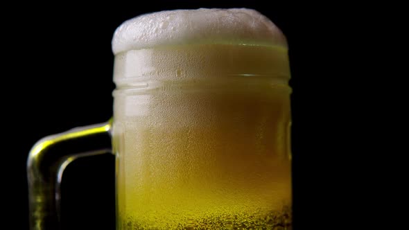 Light Beer Poured in a Mug Closeup on a Black Background