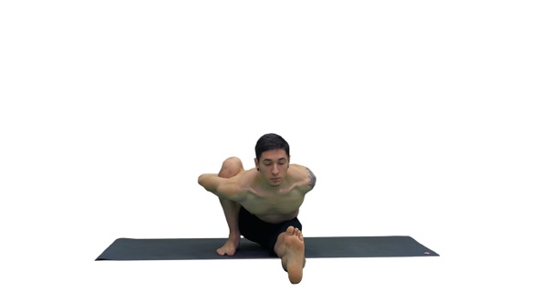 Man in Seated Marichyasana yoga pose stretching leg and alt