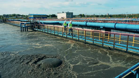Male Technicians Are Passing By the Wastewater Facilities alt