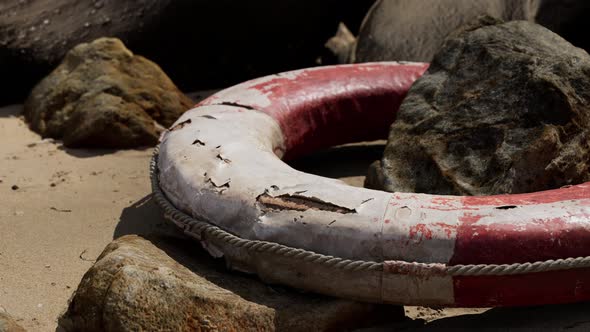 Old Life Buoy on Sandy Beach alt