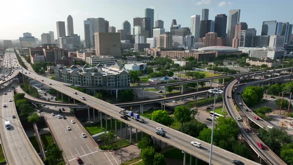 Aerial pullback reveal of downtown Houston Texas skyline and interstate traffic on freeway highways. alt