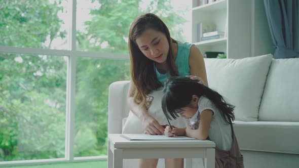 An Asian Mother Teaching Her Daughter at Home 01 alt