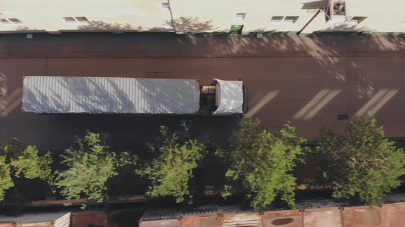 Top View of Truck with Big Sea Container Driving on Road, Aerial Shot alt