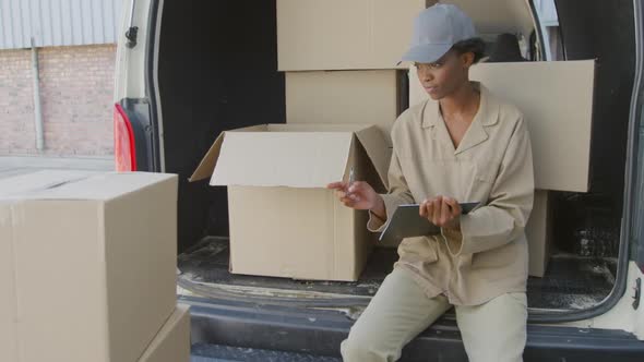 Young female van driver with a warehouse delivery alt