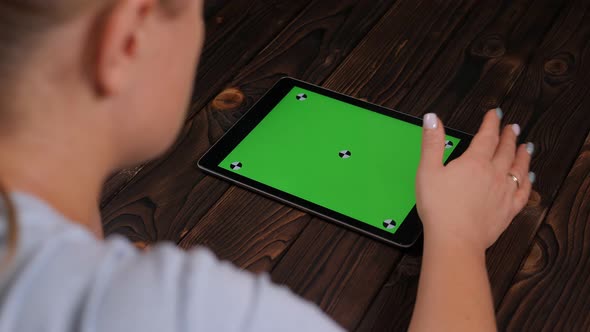 Closeup of a Young Woman Holding a Tablet with a Green Screen alt