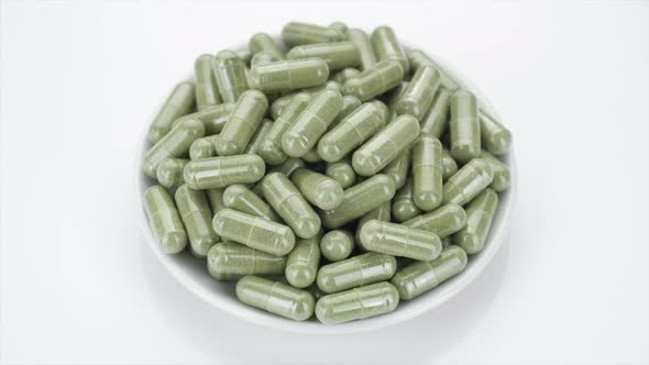 superfoods chlorella or spirulina capsules on white background, rotate. 4K UHD video alt
